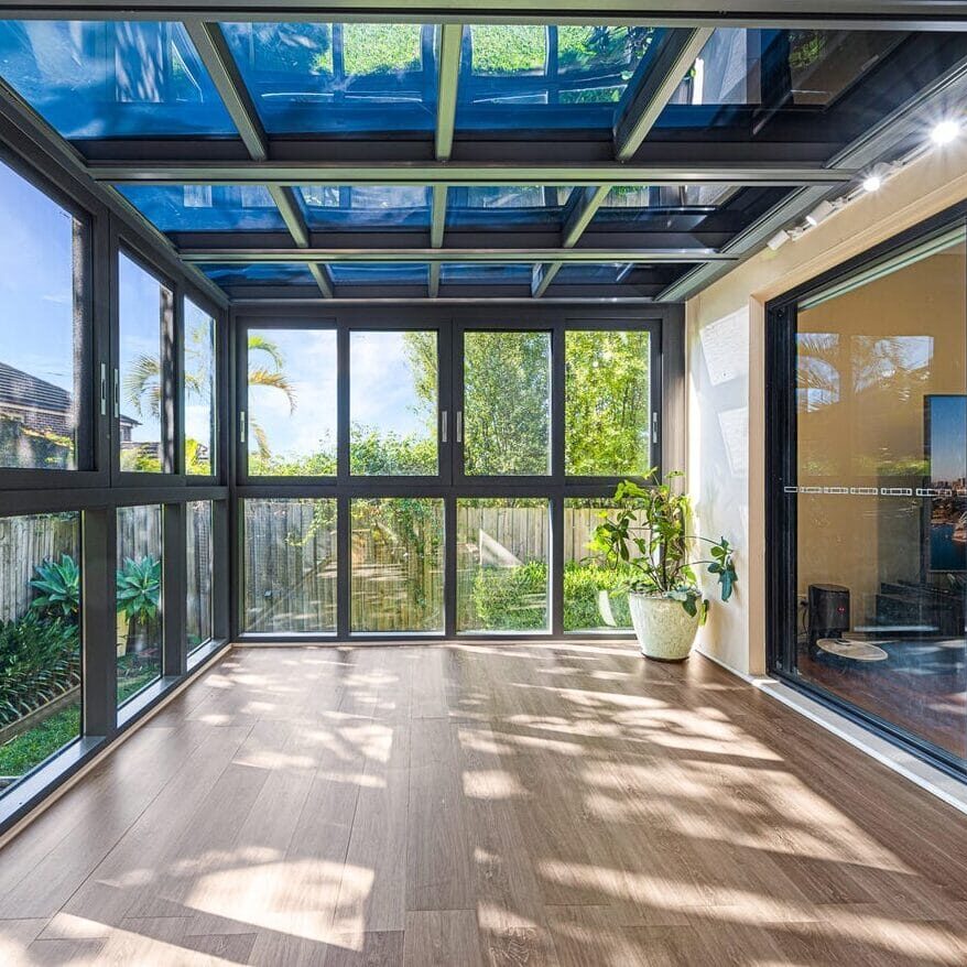 Sunroom-St Ives Modern sunroom with glass roof and sliding doors overlooking a green backyard in St Ives, Sydney