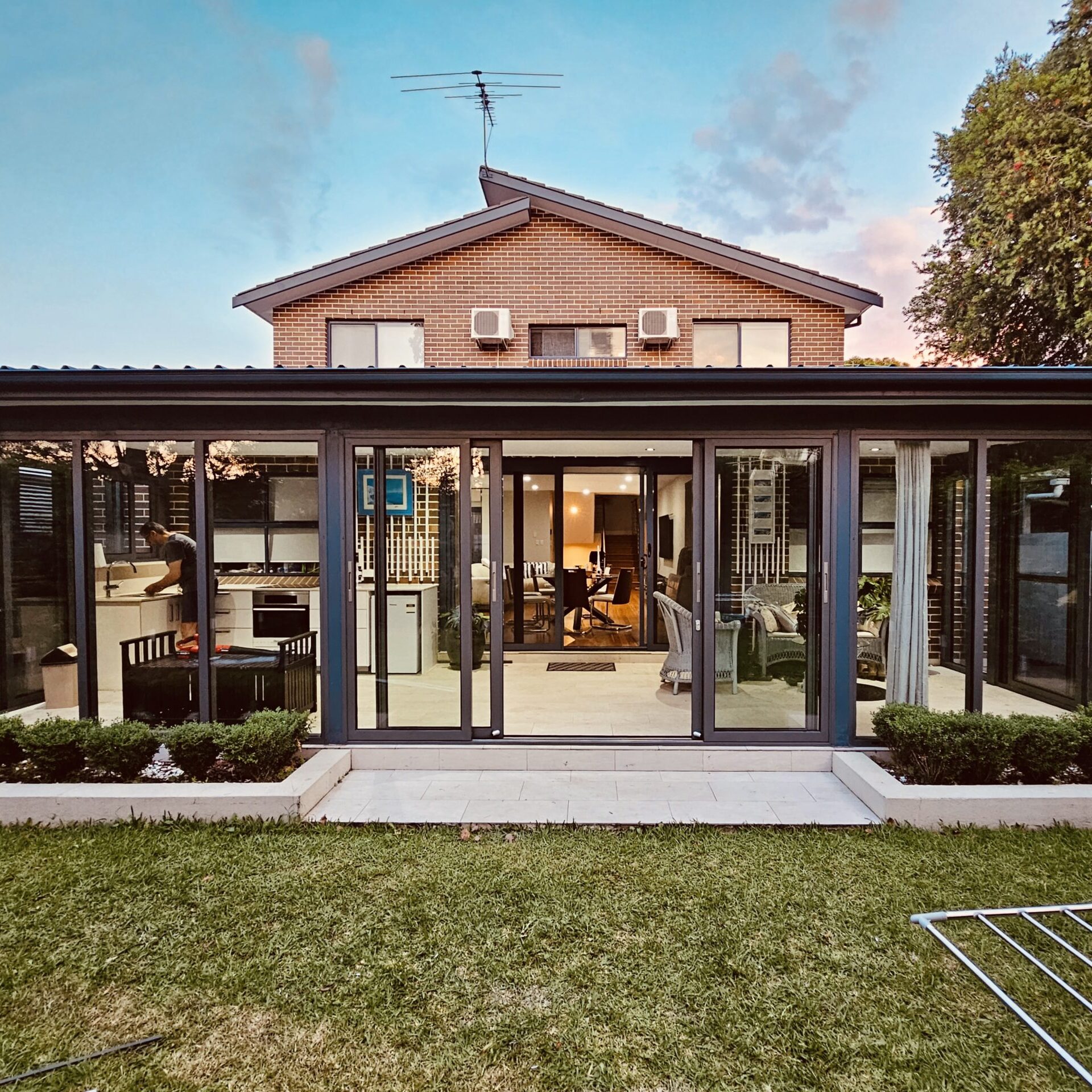 Backyard Enclosure Backyard glass enclosure with sliding doors and built-in kitchen in a modern home